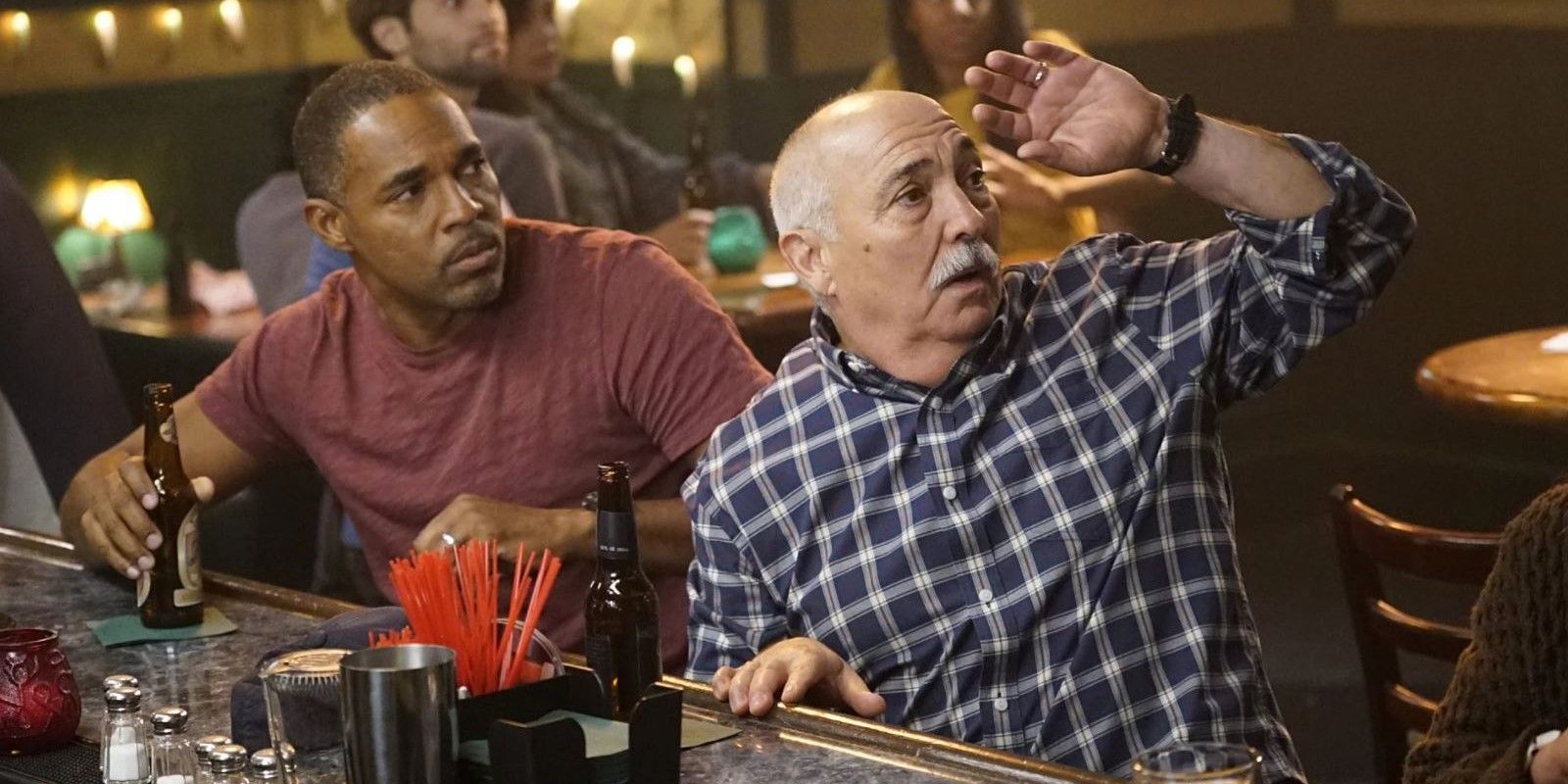 An image of Ben and Pruitt sitting at the bar. Ben is wearing a maroon shirt while Pruitt is wearing a blue and white checkered plaid