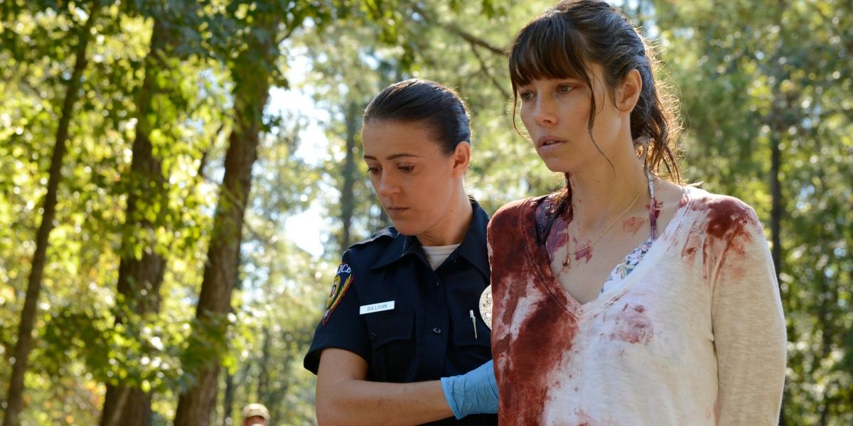 A blood-soaked Cora being taken by a policewoman