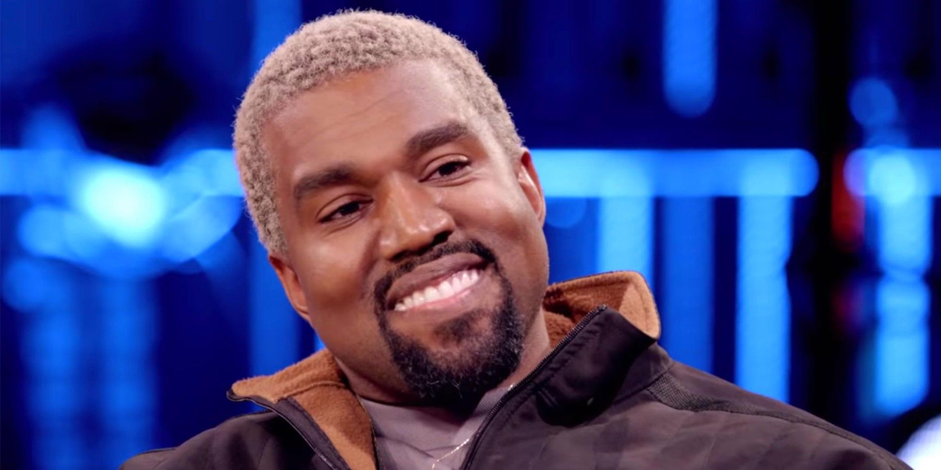 Kanye West smiling during a talk show appearance