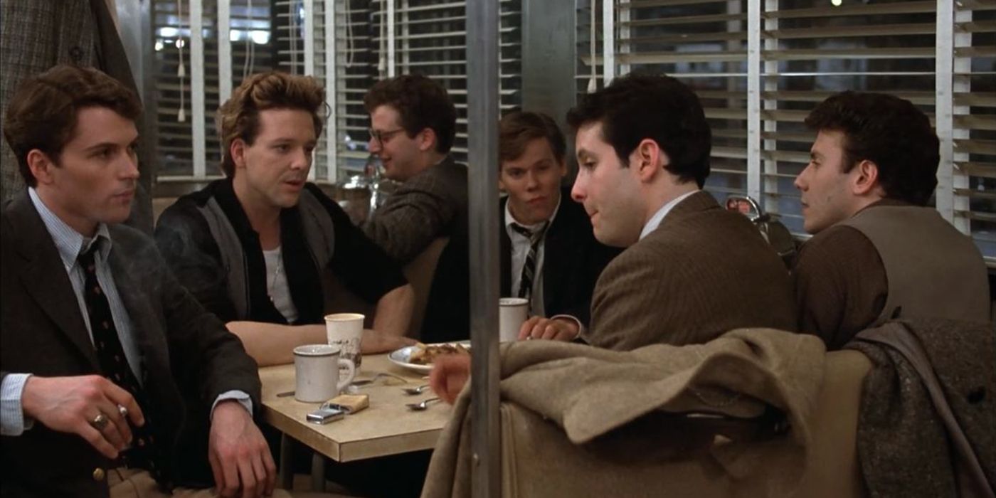 Several men sit together at a table in a diner from Diner