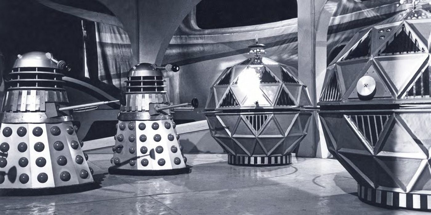 Black-and-white picture of two grey Daleks opposite the spherical Mechonoid robots