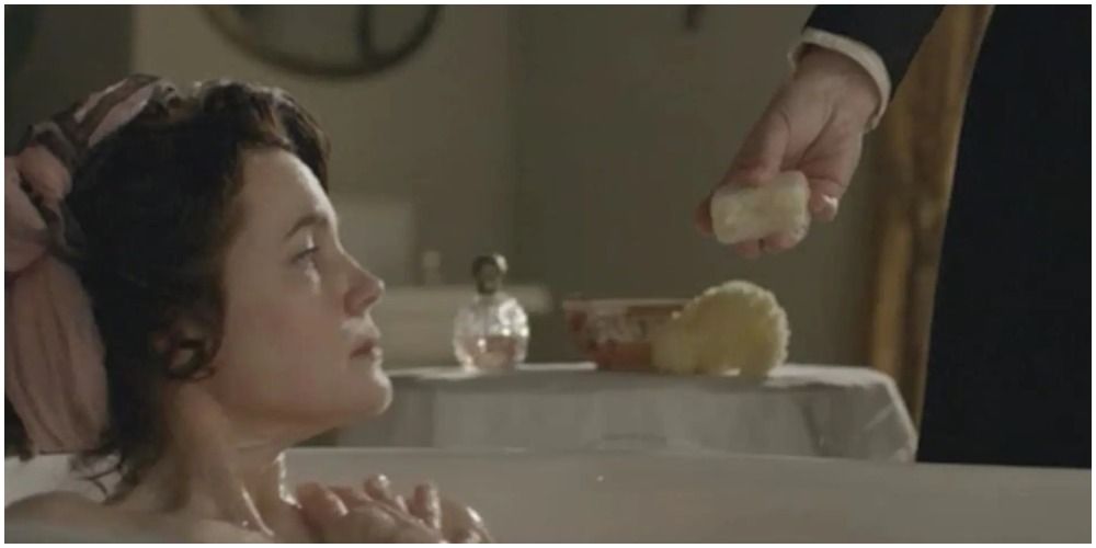 Cora in the bath being handed a bar of soap
