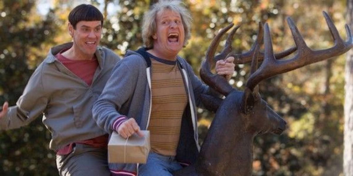 Lloyd Christmas (Jim Carrey) and Harry Dunne (Jeff Daniels) riding a deer statue in Dumb and Dumber To