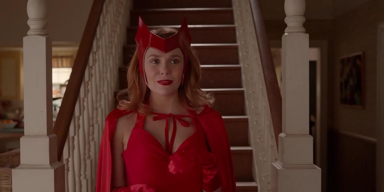 Elizabeth Olsen as Wanda in WandaVision. She is seen to be standing in front of the stairs in her house