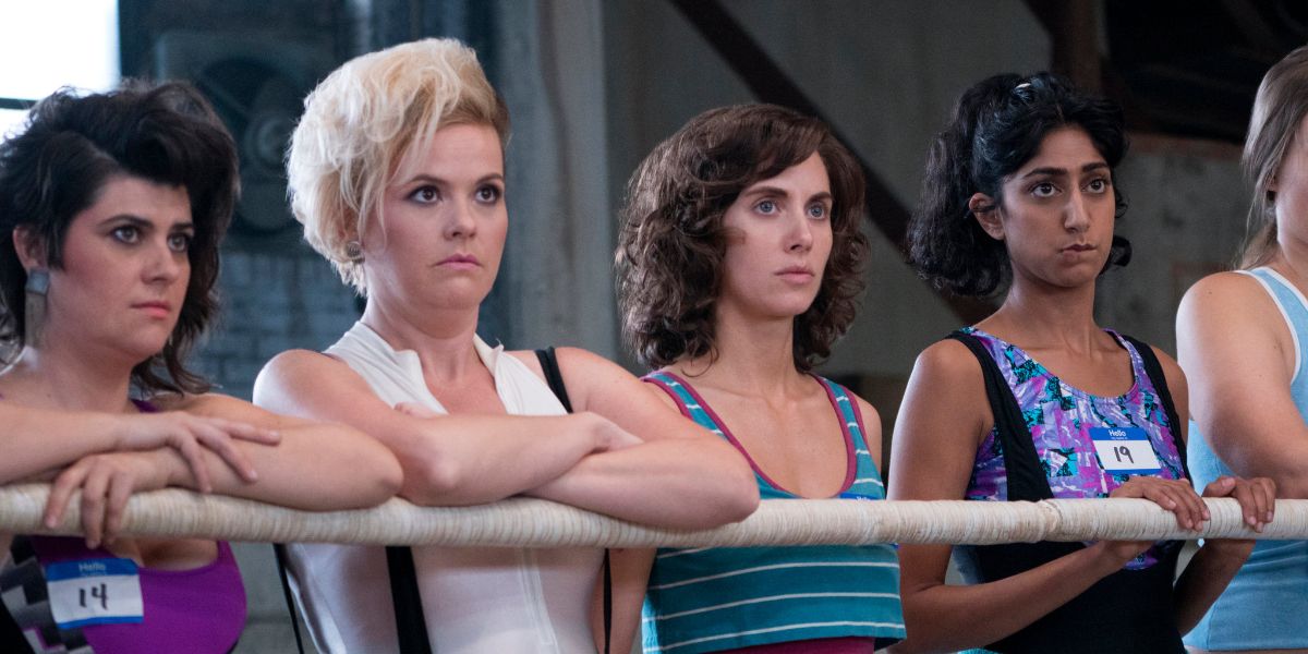 GLOW main characters standing by the ring rope 