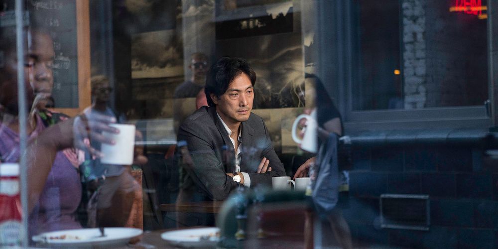 Takehiro Hira as Kenzo Mori sitting inside a restaurant in Giri Haji