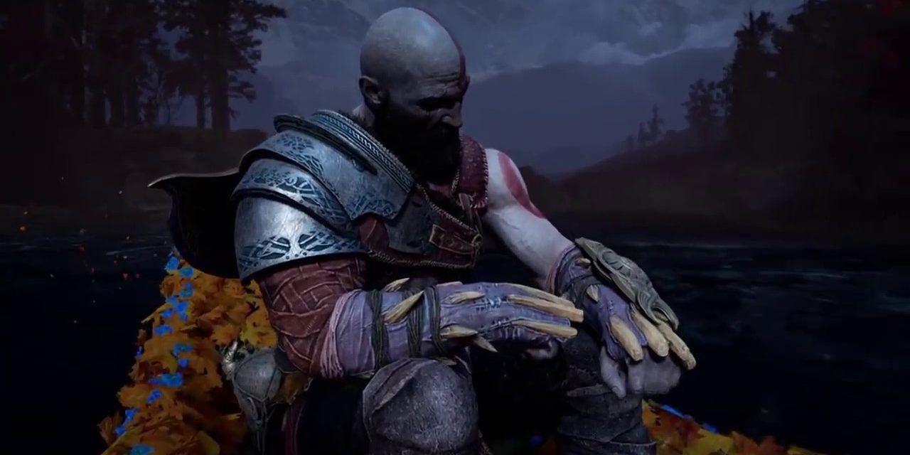 Kratos sitting and looking forlorn in God of War 
