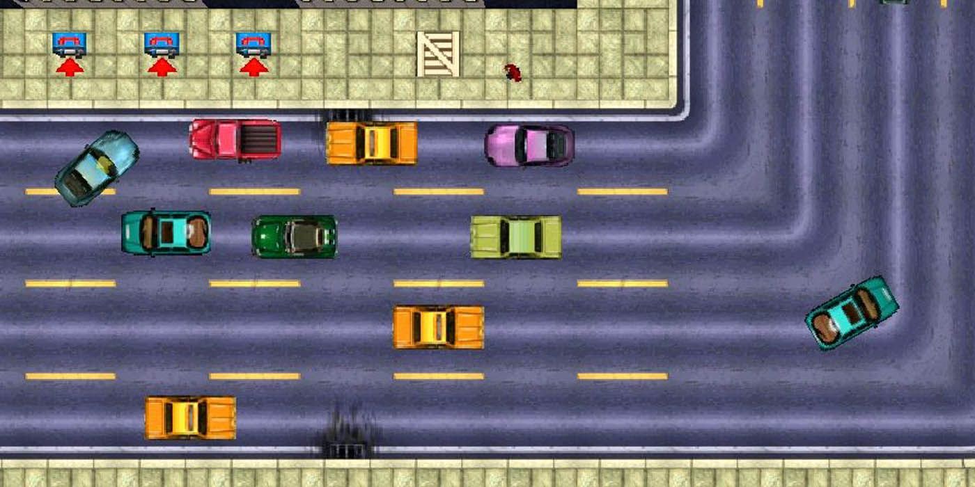 A birds eye view of the gameplay of the cars in Grand Theft Auto 1. There is a number of colored cars on the road, including orange, aqua, green, and purple