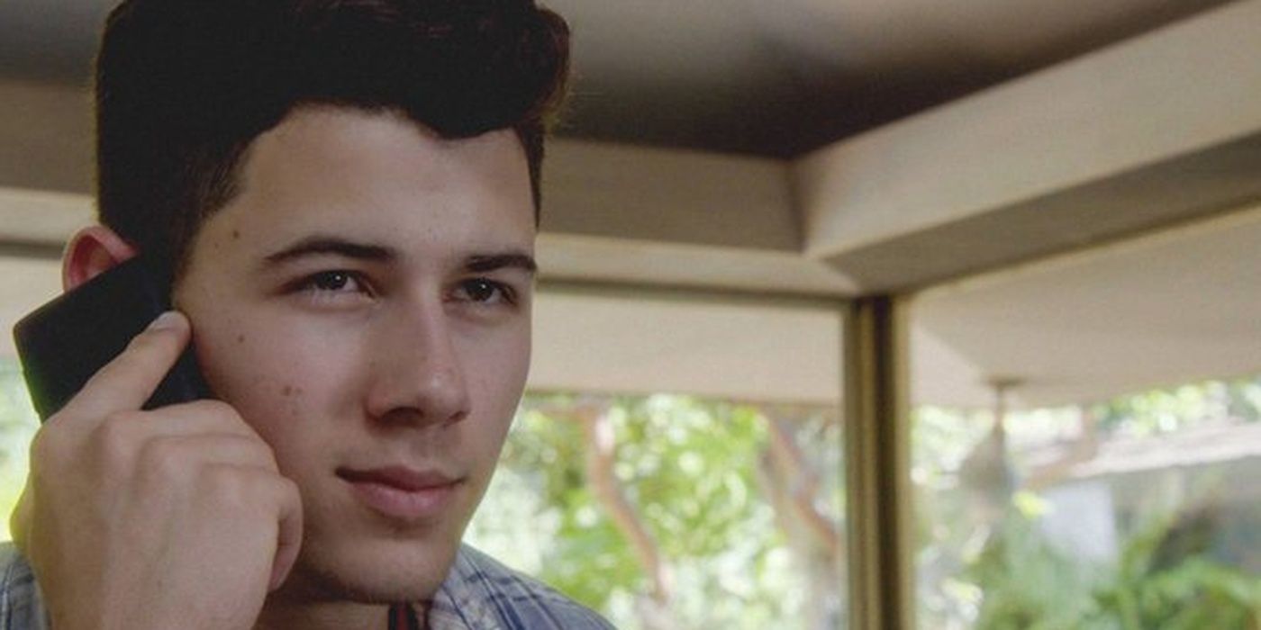 Nick Jonas as Ian Wright, holding cellphone to face in Hawaii Five-0