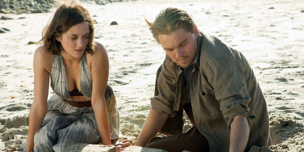 Dom and Mal Cobb, played by Leonard DiCaprio and Marion Cotillard, playing in the sand on a beach in Inception