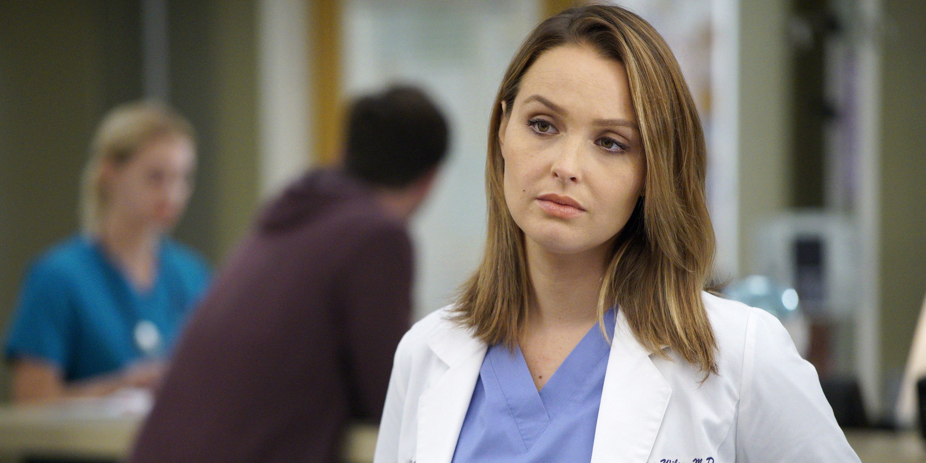 Jo Wilson looking serious in Grey's Anatomy standing in the hospital corridor