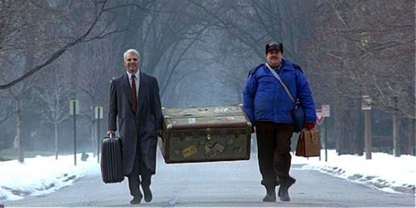 Steve Martin & John Candy carry a trunk in Planes Trains and Automobiles.