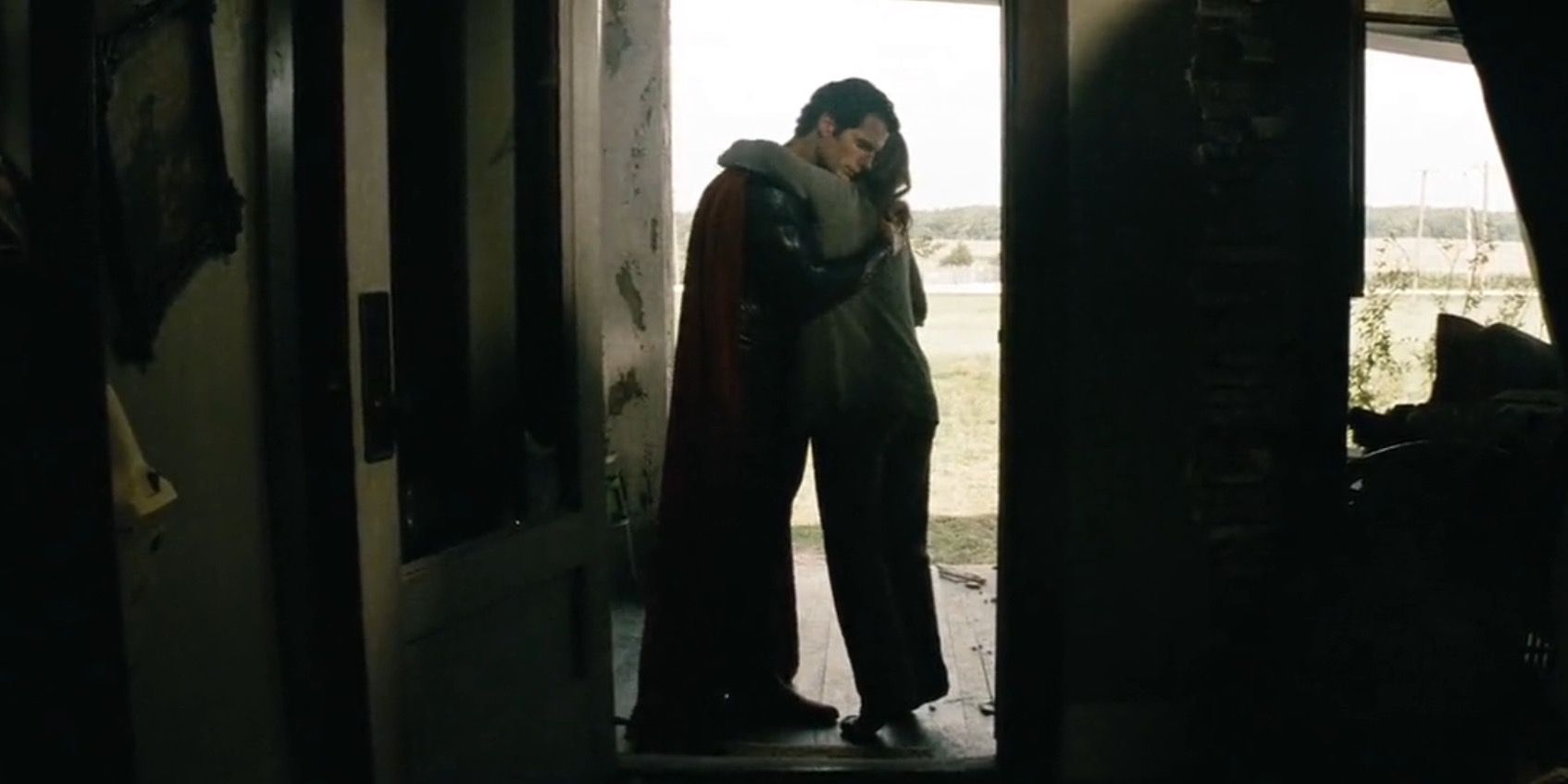 Martha Kent and Superman hugging in the doorway of the destroyed Kent house in Man of Steel