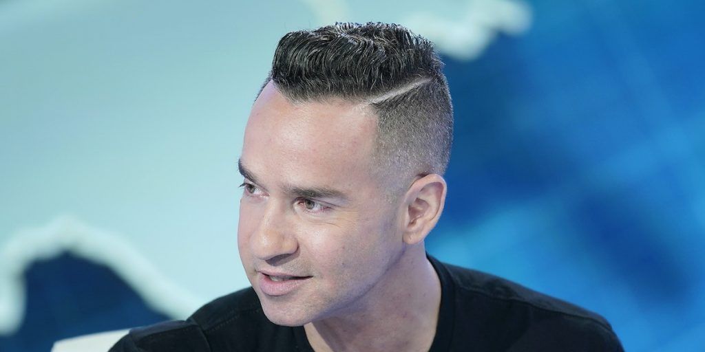 Mike Sorrentino from Jersey Shore looking to the side with a blue background.