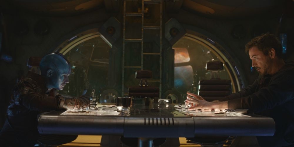 Nebula and Tony Stark sit across from each other playing a game