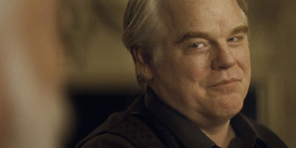 Plutarch smiling while talking to Snow in The Hunger Games