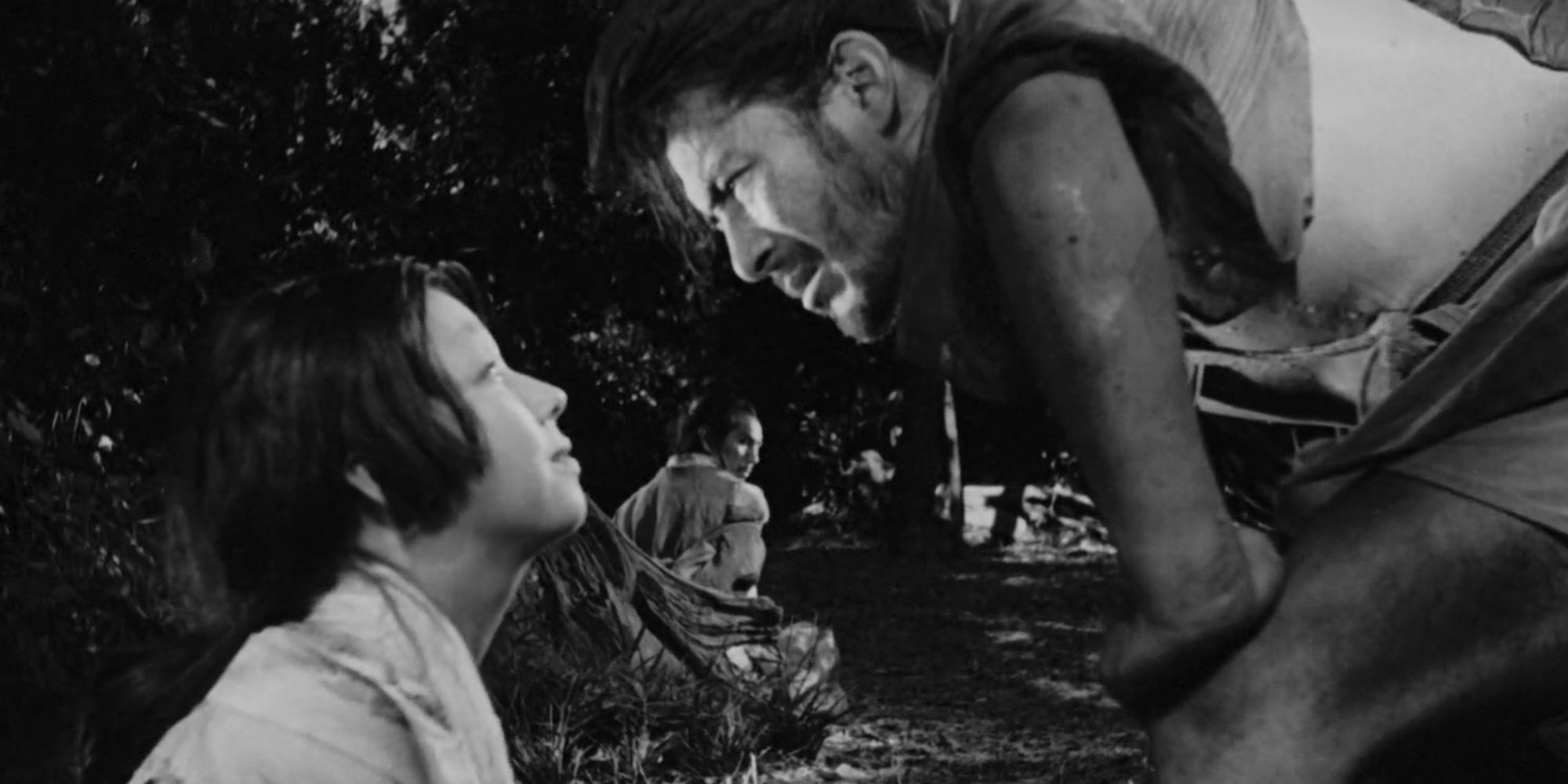 Scene from Rashomon with child and adult looking into each others' eyes.