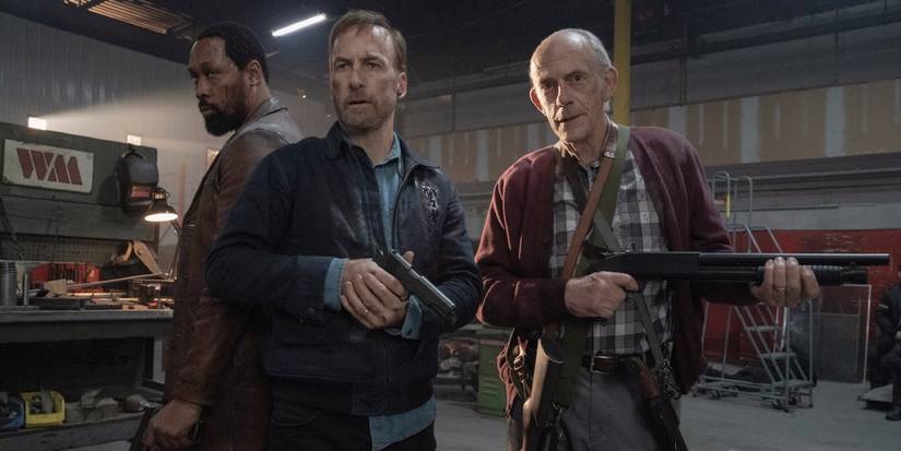 RZA, Bob Odenkirk, and Christopher Lloyd holding guns in a warehouse in Nobody