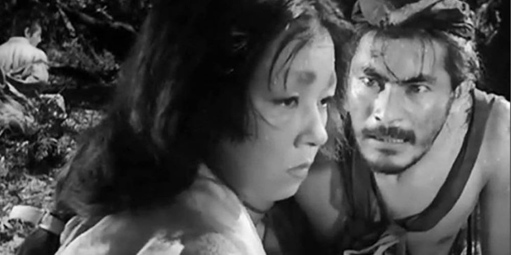 A man looking angrily at a sad-looking woman in Rashomon