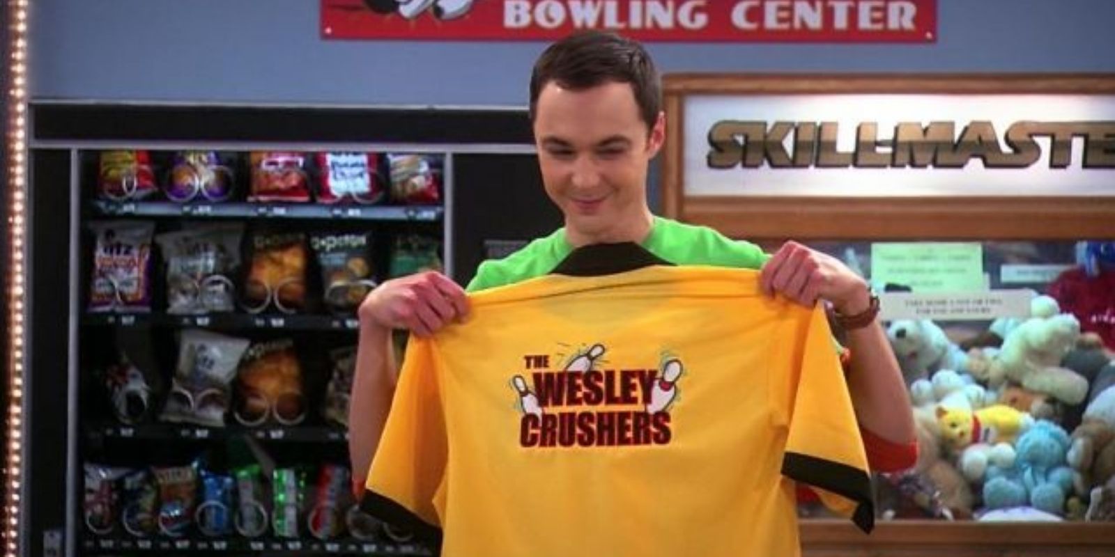Sheldon Cooper holding up a yellow bowling shirt that reads The Wesley Crushers in The Big Bang Theory