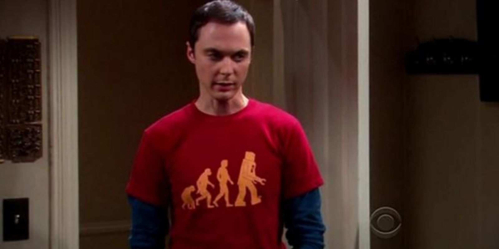 Sheldon Cooper wearin a dark red shirt with the evolution of man from ape to robot in The Big Bang Theory