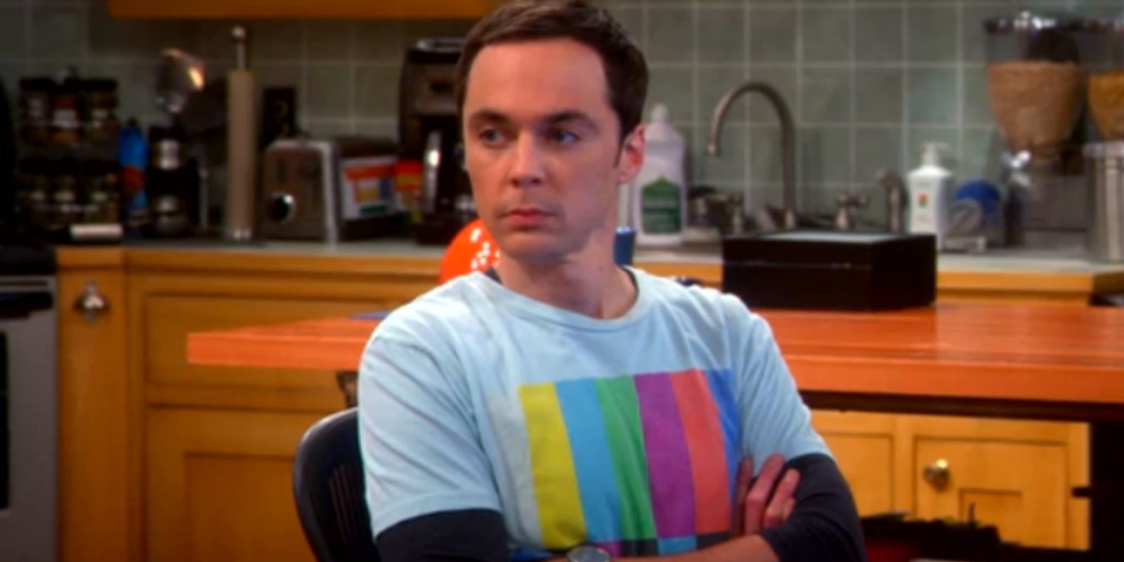 Sheldon Cooper wearing a pale blue shirt with multi color television test pattern bars in The Big Bang Theory