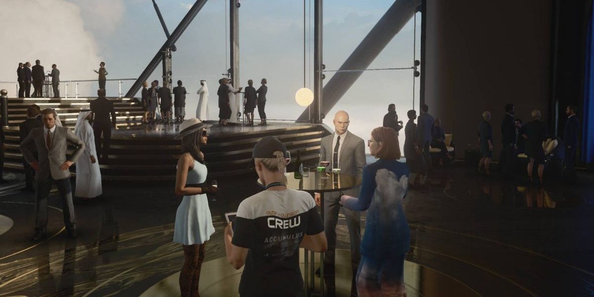 An image of Agent 47 talking to several guests at a party in Hitman 3 