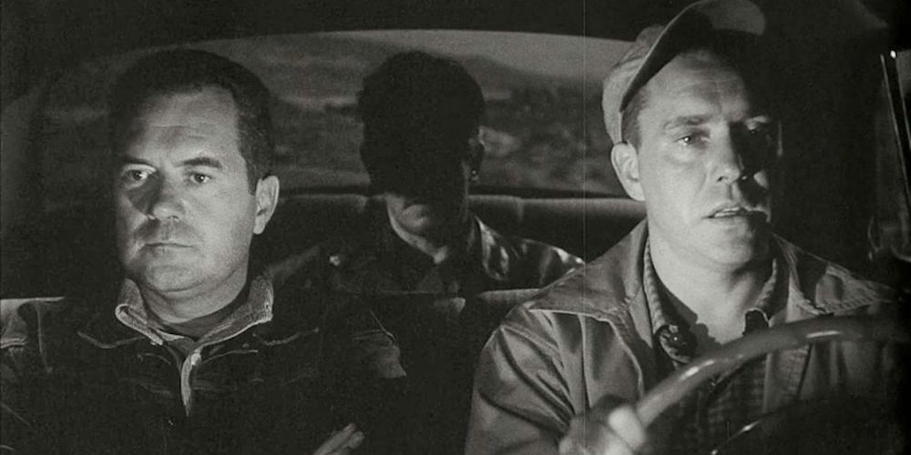 A close-up of three men driving at night in The Hitch-Hiker