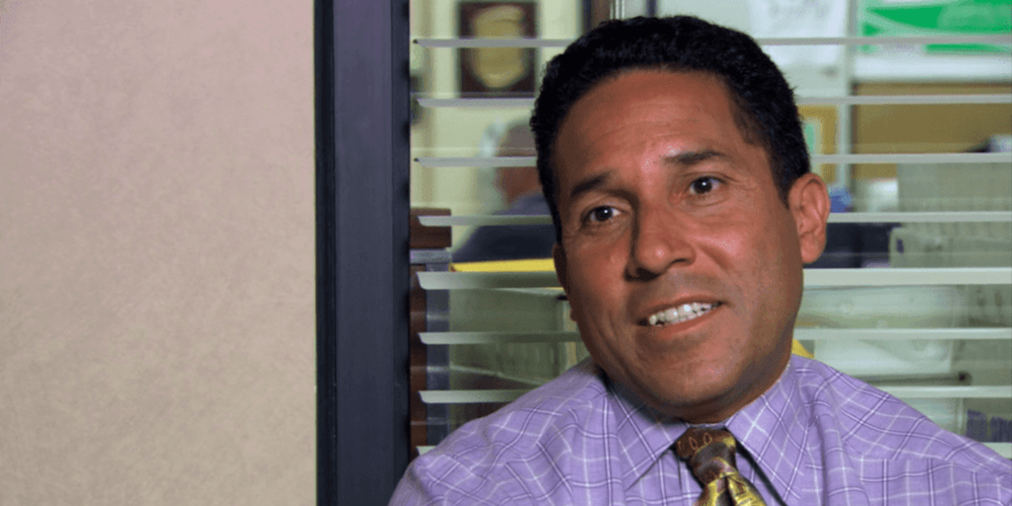 Oscar Martinez gives an awkward smile to the camera in The Office