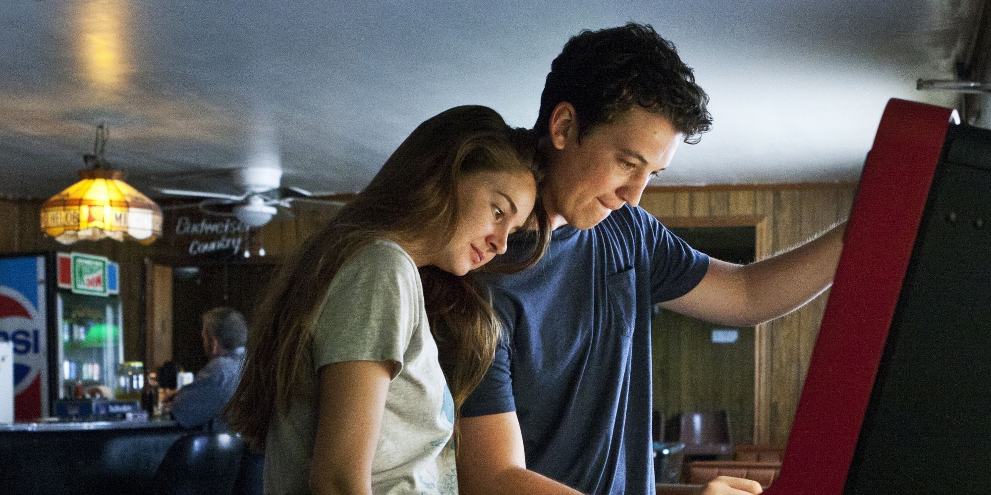 Miles Teller and Shailene Woodley standing in front of a jukebox in The Spectacular Now