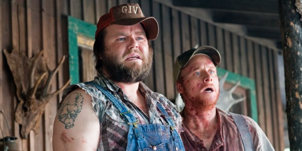 Tucker and Dale standing on cabin porch looking at something off-camera in Tucker and Dale Vs Evil