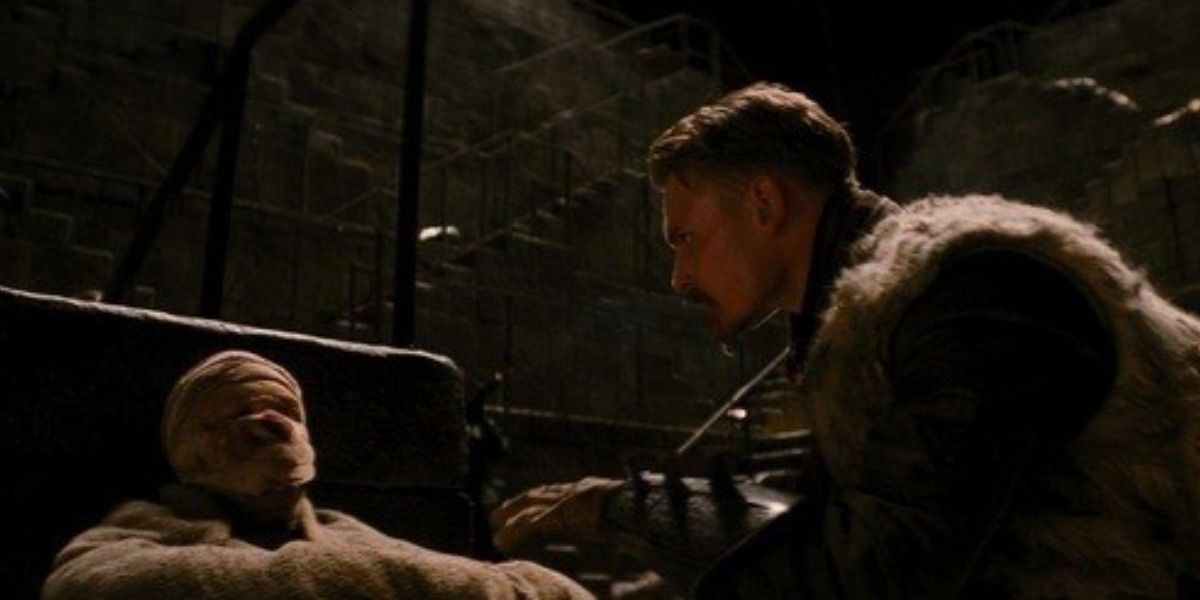 Young Ra's Al Ghul looks at injured Bane in The Dark Knight Rises