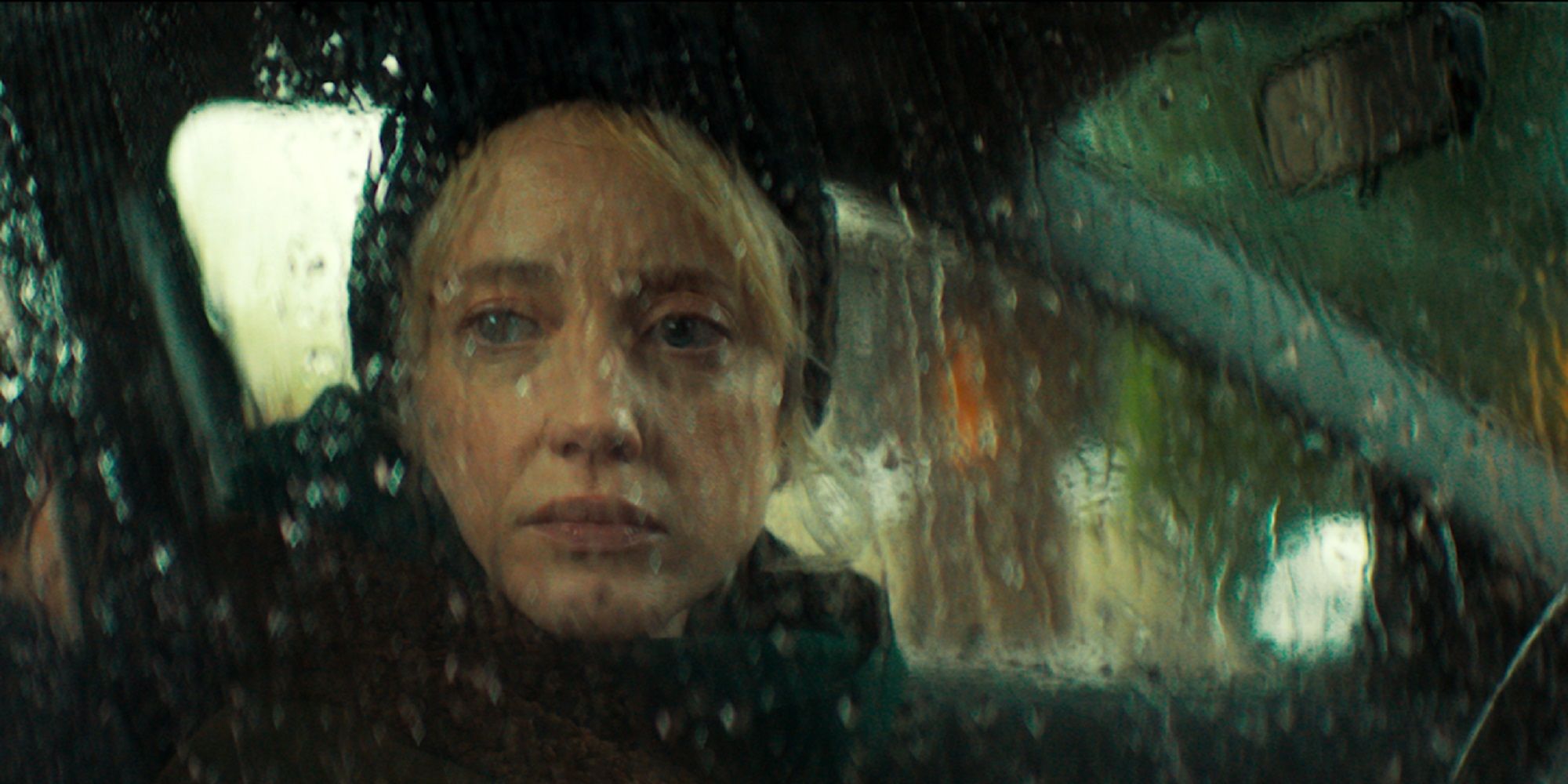 Laura looks out the car window as it rains in Here Before