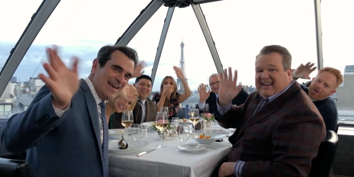 The family waving to the camera while having dinner in Paris in Modern Family