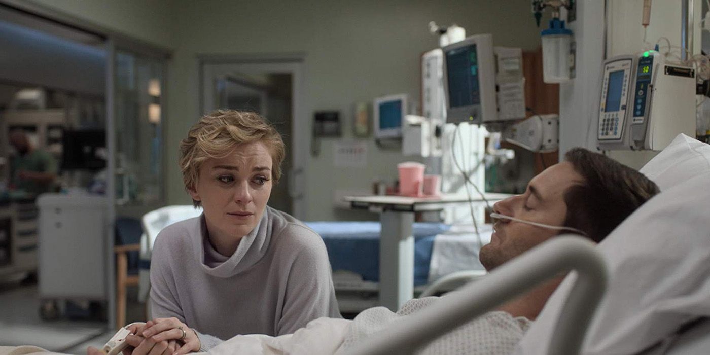 Max lying in a hospital bed with Georgia sitting beside him looking sad in New Amsterdam