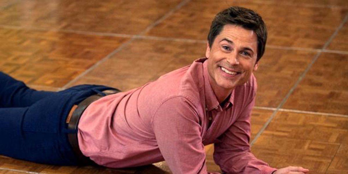 Chris Traeger laying on the floor and smiling at the camera