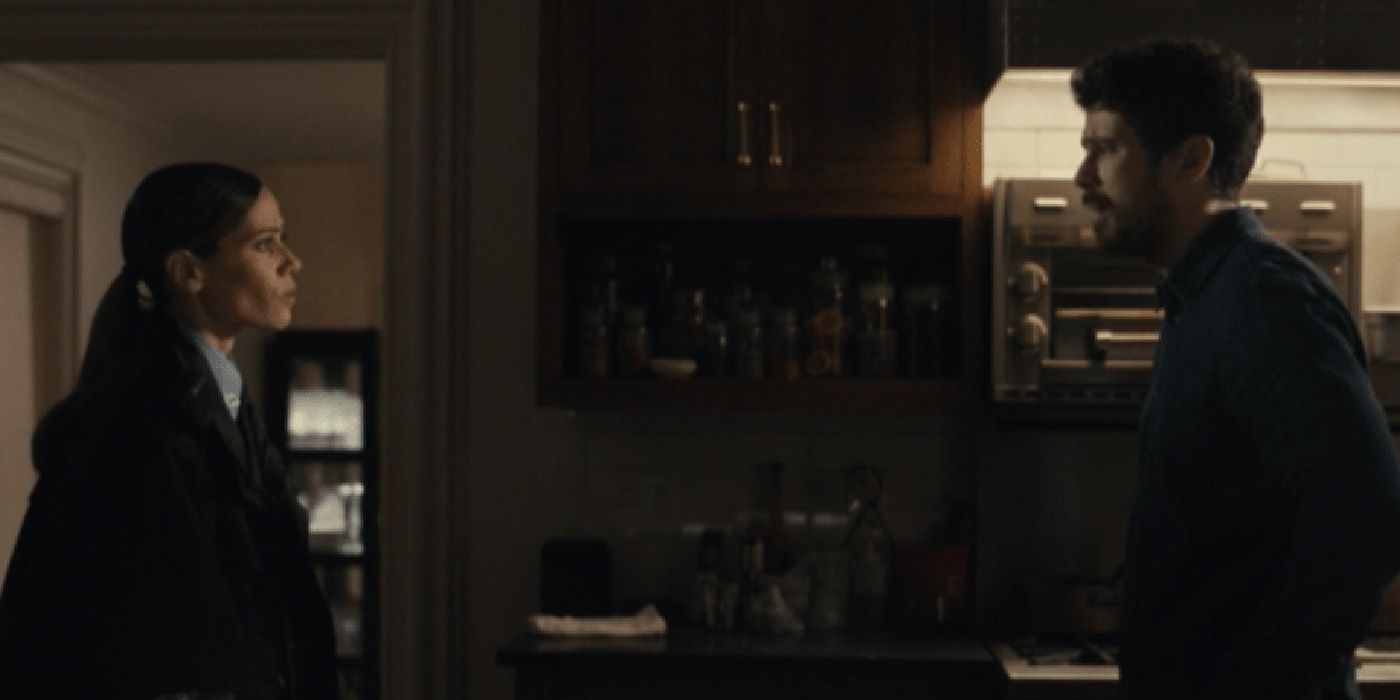 Servant's Sean standing across from the female police officer in his dining room, the two looking at one another