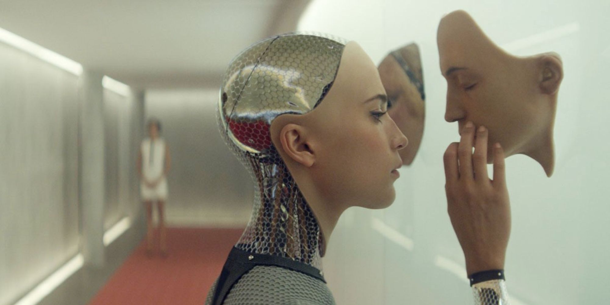 Alicia Vikander as a cyborg touching an artificial face on the wall in Ex Machina
