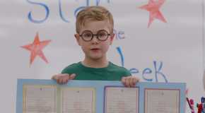 Austin from Ginny & Georgia Holds up his poster for a class presentation
