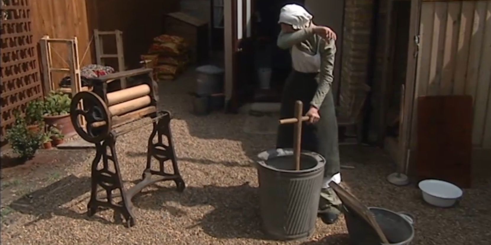 Woman churning butter outside house in 1900 House