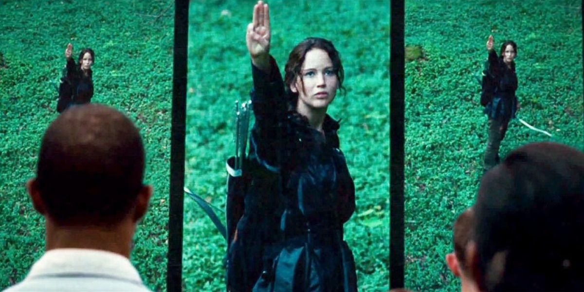 Katniss saluting to the cameras in The Hunger Games