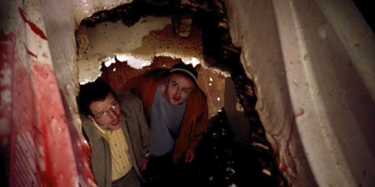 Walt and Jesse look through a hole in the floor
