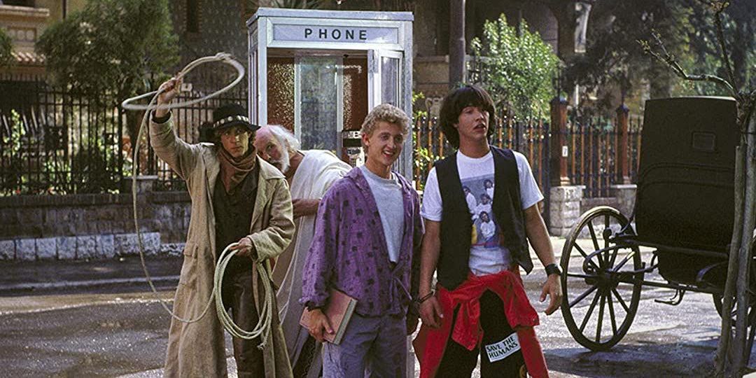 Bill and Ted standing in the street in the early 19th century with Socrates and Billy the Kid behind them with the time machine