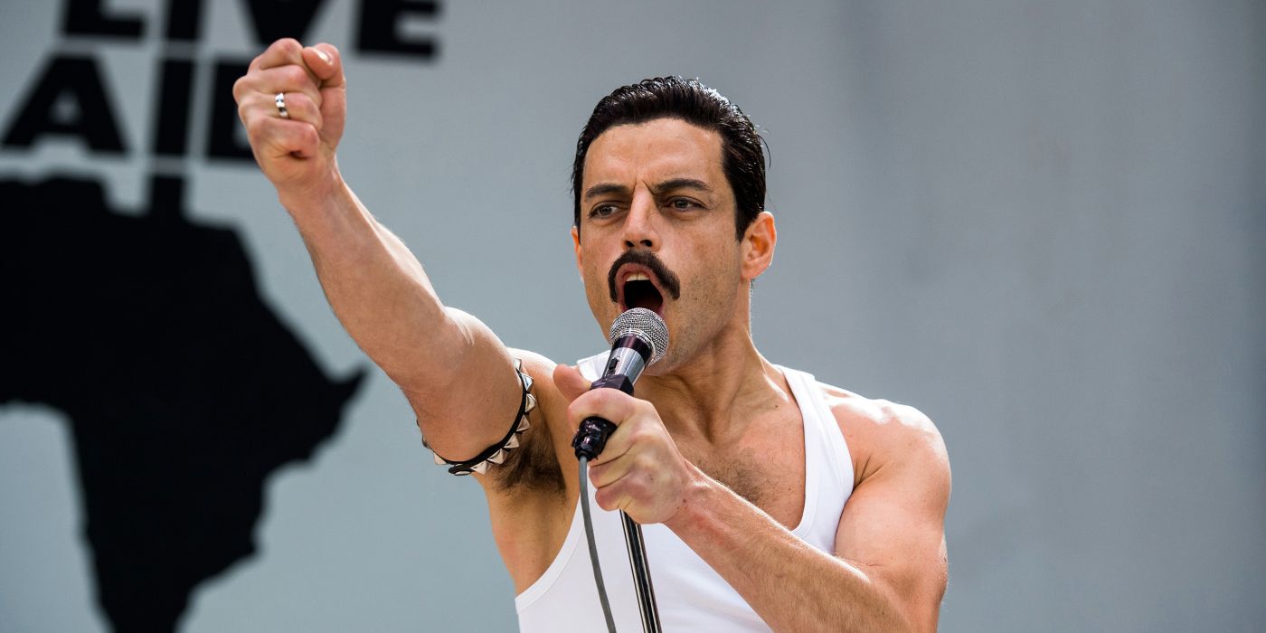 Freddie Mercury raises his fist as he sings on the stage in Bohemian Rhapsody.