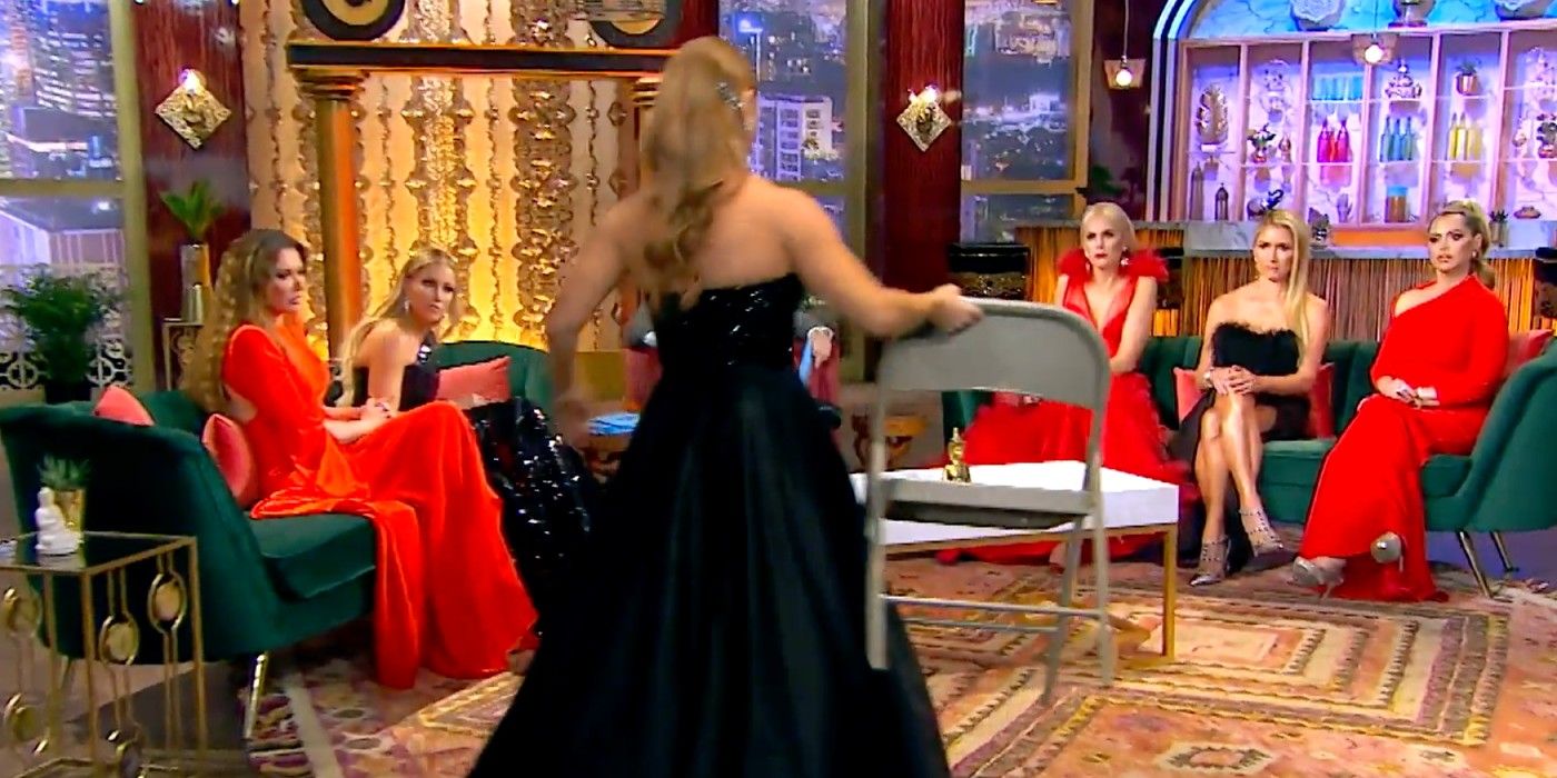 Brandi Redmond picks up a folding chair in front of the other housewives