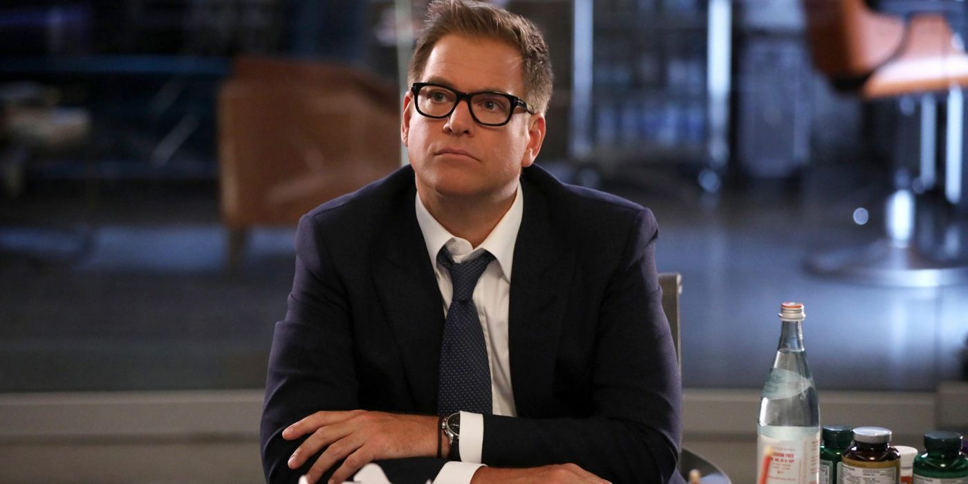 Michael Weatherly sitting at a table appearing lost in thought in Bull