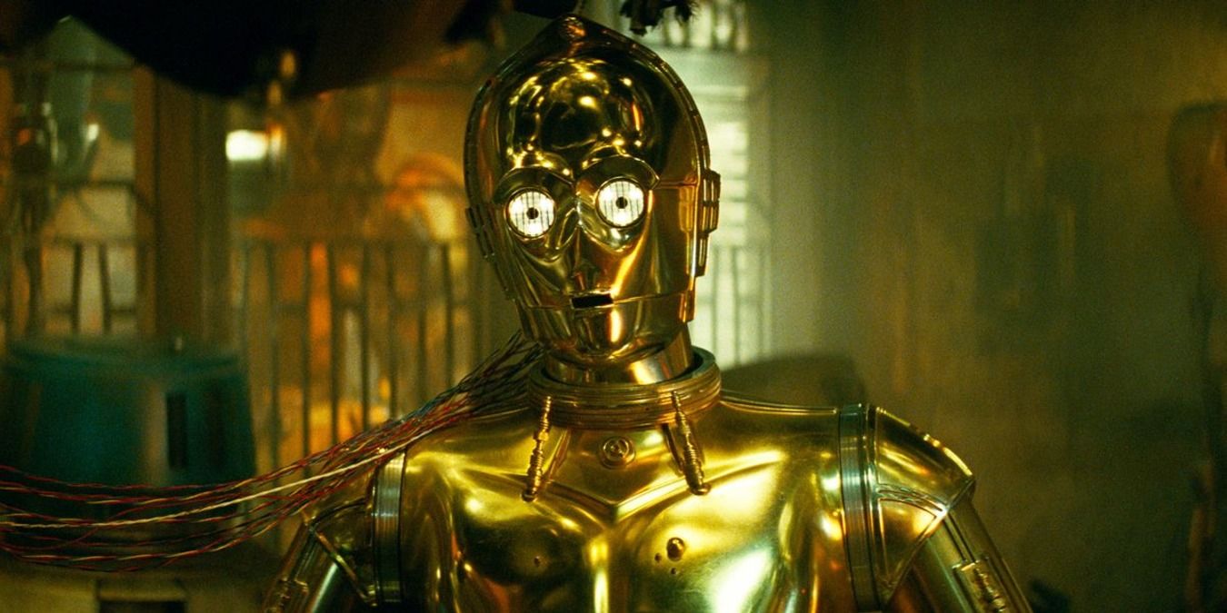 C-3PO standing with wires attached to him