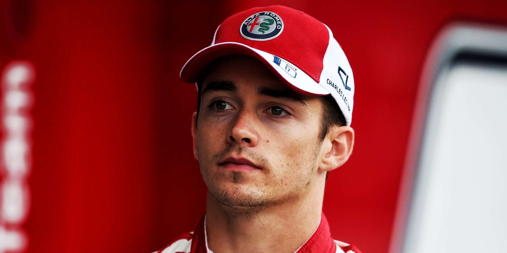 Charles Leclerc stands at the podium after a win