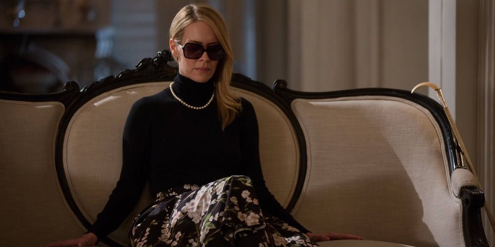 Cordelia Foxx sitting on a couch with her sunglasses on in Coven