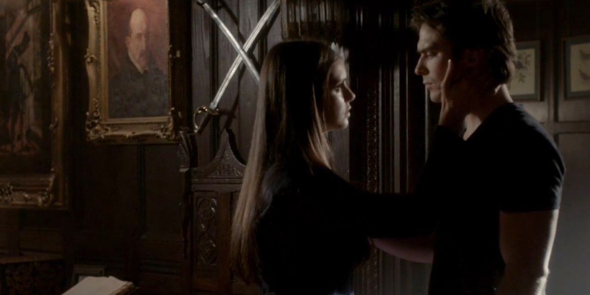 Elena holds Damon's face in The Vampire Diaries.